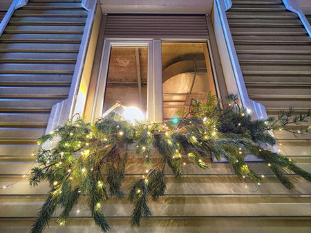 Festive pine branches adorned with twinkling lights enhance the charm of a home during the holiday season.の写真素材