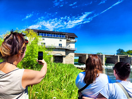 Friends enjoy sunny outing by the river, capturing memories near the damの写真素材