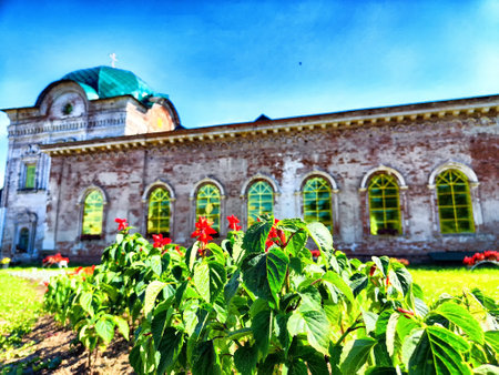 A historic features structure large windows surrounded by blooming flowers on a sunny day.の写真素材