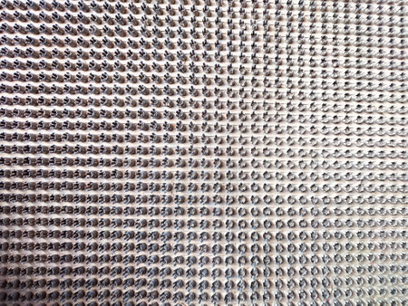 abstract background of a metal surface with holes in the form of a gridの写真素材