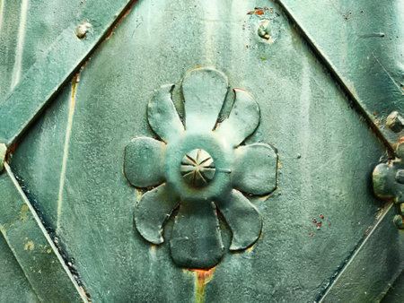 The intricately crafted metal surface showcases a floral design embedded in a rich green texture, emphasizing artistic detailing.の写真素材