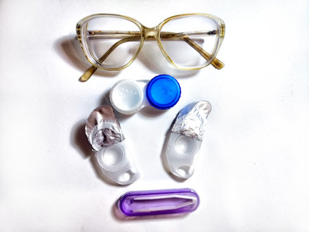 A pair of stylish glasses is placed alongside contact lens case and solution, showcasing daily eyewear essentials for eye careの写真素材