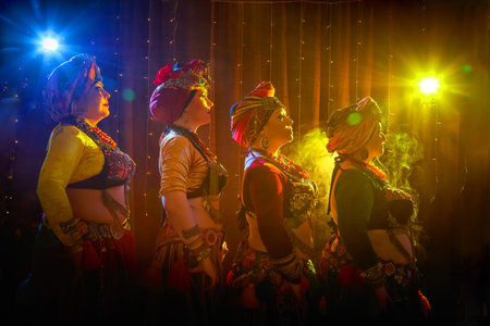 Four women in colorful traditional costumes pose for a photo. A tribal dancer poses for a photo shootの写真素材