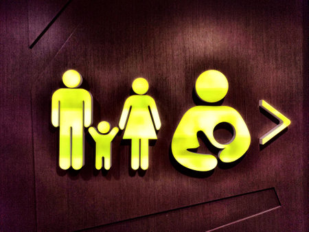 A sign indicates a designated area for nursing, showing symbolic figures of a family with a mother breastfeeding her child.の写真素材