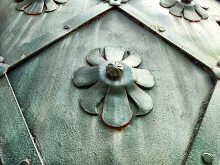 An intricate metal panel showcases floral patterns and textures, reflecting urban artistry and craftsmanship from a close perspective.の写真素材