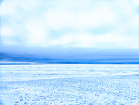 Melting ice flows down the river as a snowy road crosses the landscape, marking the change of seasons and warming weather.の写真素材