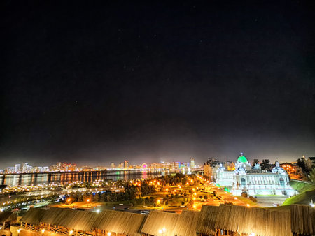 The vibrant skyline of Kazan at night showcases bright lights, reflecting rivers, and historic...
