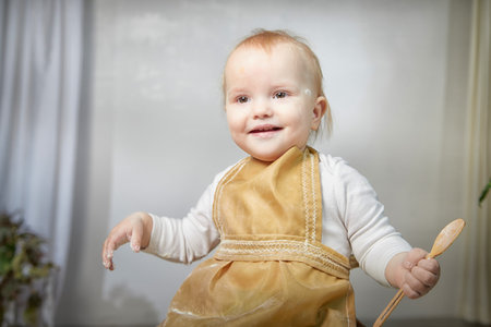 A young girl joyfully plays with flour during a creative cooking-themed photo shoot in a studio settingの写真素材