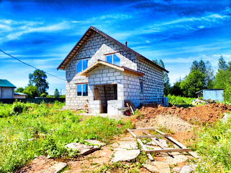 A house under construction with a large yard and clear summer sky.の写真素材