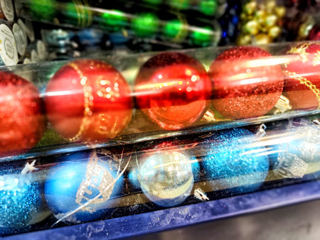 Rows of vibrant red and blue Christmas ornaments are showcased, reflecting the spirit of the holiday season in a bustling shop.の写真素材