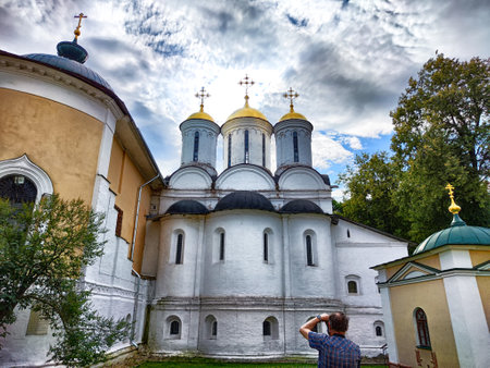 Visitors admire the stunning Kremlin in Yaroslavl, showcasing its unique architecture and golden...