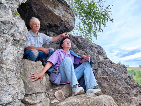 Couple enjoying nature and rock formations in a serene outdoor setting during a sunny dayの写真素材
