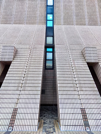 A long, tiled pathway with multiple arched entrances leads to modern brick building in Hong Kongの写真素材