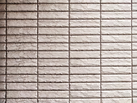 Subtle textured wall featuring a brick-like pattern, perfect for showcasing text or graphics in design projects and presentations.の写真素材