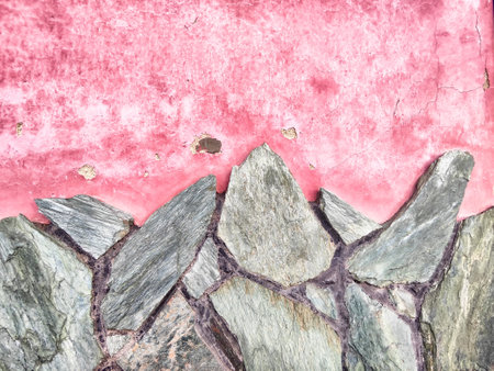 A rustic pattern combines jagged stone and peeling pink paint, offering a vibrant space for text and artistic expression.の写真素材