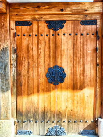 Captivating wooden door boasts detailed metal accents and a rustic finish, showing casing craftsmanship in a historical structure.の写真素材
