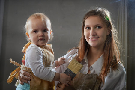 Mother and daughter in aprons joyfully playing with flour during a fun kitchen-themed photo shoot at homeの写真素材