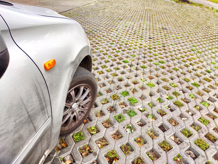 A car parks on an eco-friendly surface designed to support vegetation and reduce environmental impact.の写真素材