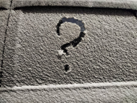 A question mark drawn on a frosted surface reflects feelings of insecurity and uncertainty in a business context during winter.の写真素材