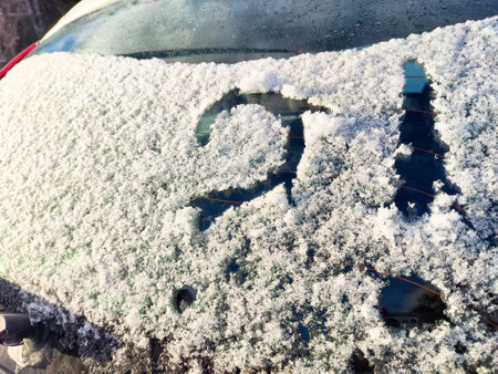 Frost covers a vehicle's rear windshield with a question mark drawn into the snow, hinting at uncertainty about cleaning.の写真素材