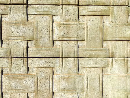 Detailed concrete wall displays a woven pattern, providing a visually appealing texture ideal for...