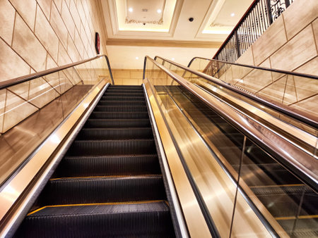 Escalator ascends through a stylish shopping center, showing polished surfaces and intricate...