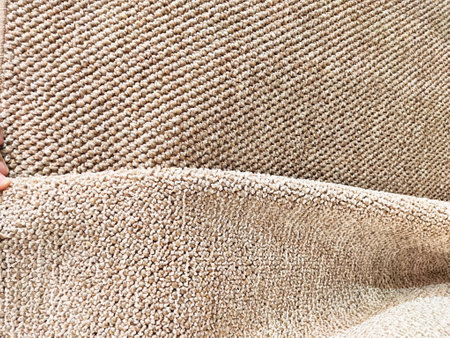 Soft beige carpet is being laid down in a stylish apartment, enhancing comfort and warmth in the living area.の写真素材