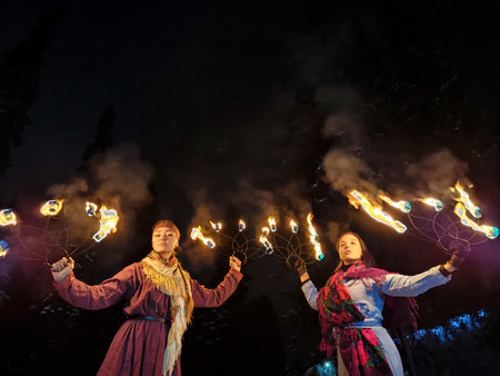 Actors in ethnic costumes perform a captivating fire show, celebrating Viking culture amid the winter chill and frosty ambiance of the night.の写真素材