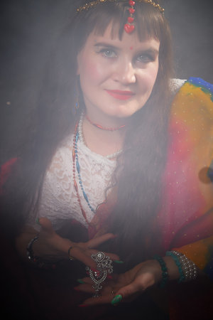 Blonde woman dressed in colorful sari showcasing traditional jewelry during Indian style photoshootの写真素材