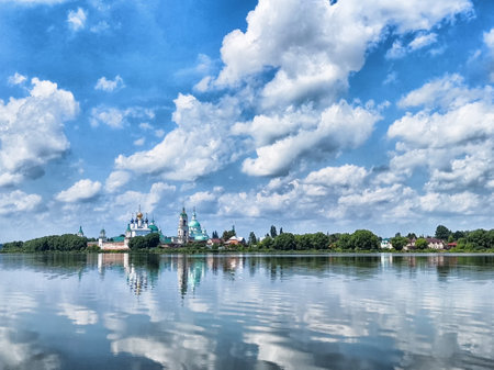 The Kremlin in Rostov the Great is beautifully reflected in the calm waters, surrounded by lush greenery and picturesque clouds.の写真素材