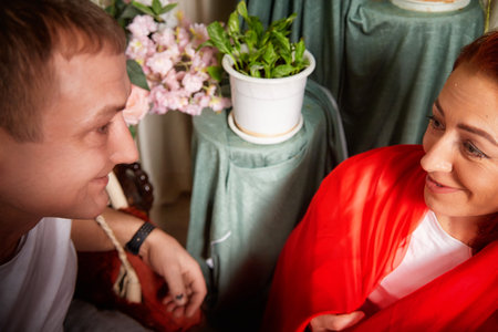 Middle-aged couple enjoys playful role-playing in oriental attire during a fun indoor photo shoot