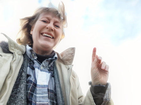 Middle-aged woman takes a selfie, smiling brightly while exploring new destinations on her travel...