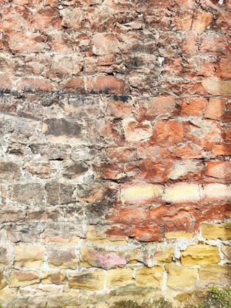 A rustic stone wall showcases a blend of warm hues and varied textures, providing a versatile...