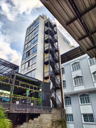 A high-rise building showcases modern design alongside a cozy outdoor dining area and a prominent...
