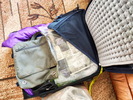 Suitcase is open and organized, filled with clothes and travel items, highlighting careful packing...