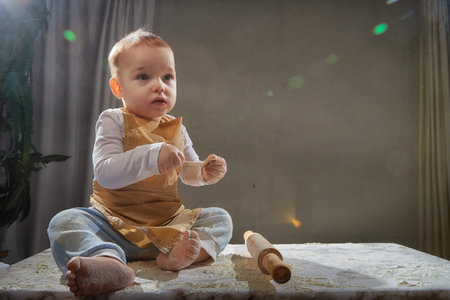 A young boy joyfully plays with flour during a creative cooking-themed photo shoot in a studio settingの写真素材