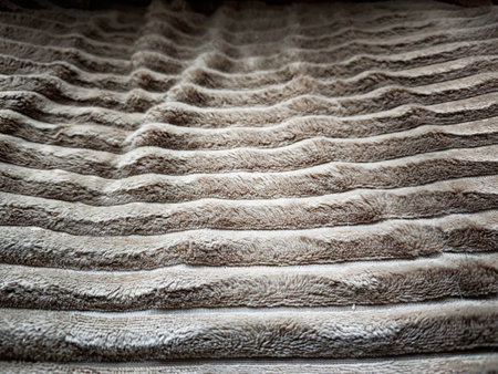 Close-up view of a soft, textured fabric displaying wavy lines, ideal for backgrounds in design or home decor concepts.の写真素材