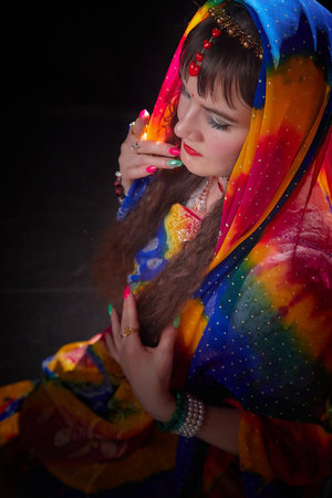 Mature woman in vibrant sari poses elegantly during a traditional Indian photoshoot, showcasing cultural beauty and styleの写真素材
