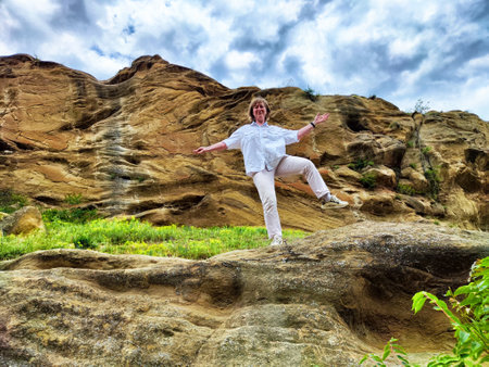 Blonde woman enjoys an adventurous moment while exploring rocky landscapes during her travels into the great outdoors.の写真素材