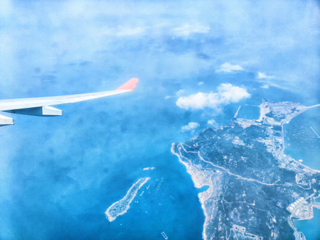 Aerial view showcases a vibrant coastline with blue ocean waters and islands, captured during a flight under clear skies.の写真素材