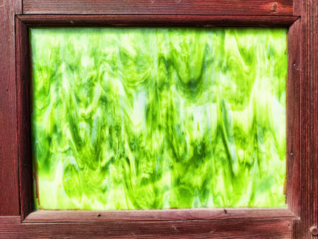 Bright green abstract texture is enclosed within a simple wooden frame, offering a vibrant backdrop suitable for creative text placement.の写真素材