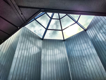 Skylight reveals a geometric design that frames clouds and sky above, emphasizing innovative architectural elements and natural light.の写真素材