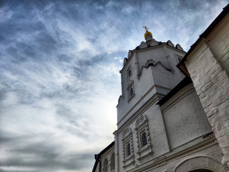 A striking church tower with intricate details stands tall under a moody sky, evoking a sense of peace during twilight hours.の写真素材