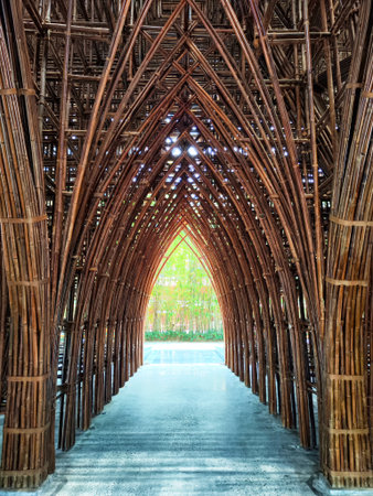 A beautiful bamboo structure forms an arching pathway leading to a lush green garden, offering tranquility and natural beauty.の写真素材