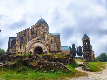 A magnificent old church stands on rocky terrain, enveloped in mist and lush greenery, highlighting architectural beauty and serenity.の写真素材