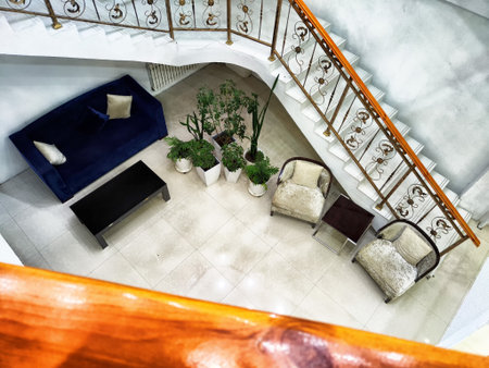 A cozy lounge area features a navy blue sofa, elegant armchairs, and potted plants, creating a tranquil atmosphere in a contemporary space.の写真素材