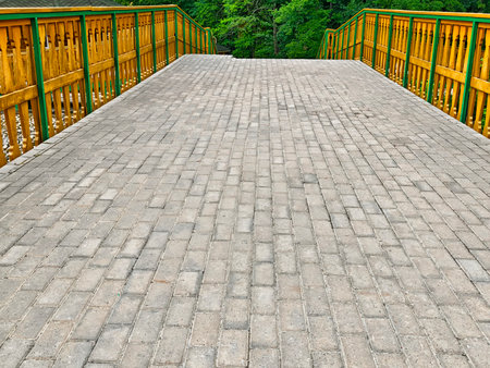 A strong bridge of stone and wood beckons visitors to explore the lush forest, highlighting the bond between nature and relaxation.の写真素材