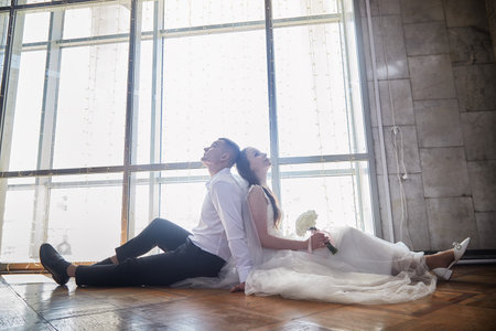 Couple shares a tender moment during wedding registration with artistic backdrop and natural lightの写真素材