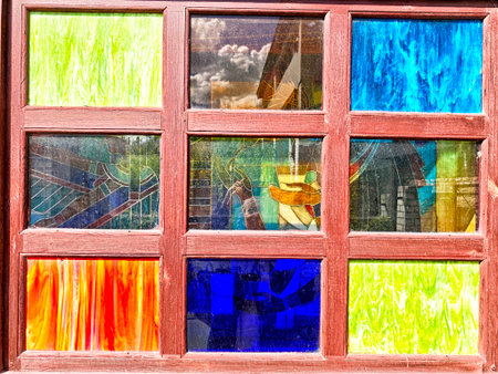 Colorful stained glass panels create a striking visual display in a sunlight-filled setting, showing artistic patterns and vibrant hues.の写真素材