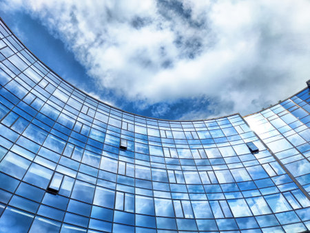 Clouds reflect on the glamping surface of a contemporary glass building in Innopolis, showcasing a bright and clear sky.の写真素材